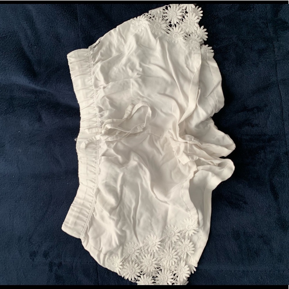 White soft shorts with flower cut outs on side